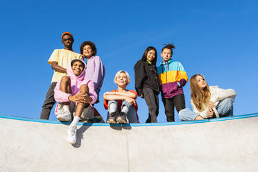 Multikulturelle Gruppe junger Freunde, die sich im Freien treffen und Spaß haben - Stylische, coole Teenager treffen sich im städtischen Skatepark - DMDF02936