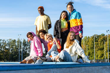 Multikulturelle Gruppe junger Freunde, die sich im Freien treffen und Spaß haben - Stylische, coole Teenager treffen sich im städtischen Skatepark - DMDF02940