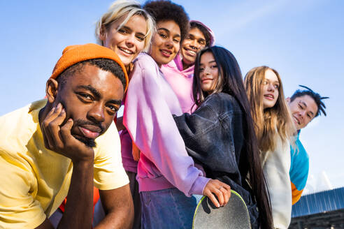 Multikulturelle Gruppe junger Freunde, die sich im Freien treffen und Spaß haben - Stylische, coole Teenager treffen sich im städtischen Skatepark - DMDF02946