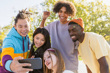 Multicultural group of young friends bonding outdoors and having fun - Stylish cool teens gathering at urban skate park - DMDF02952