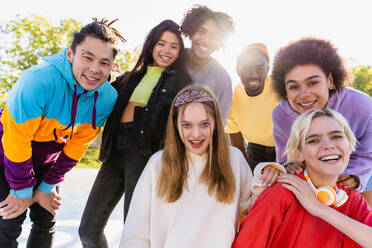 Multicultural group of young friends bonding outdoors and having fun - Stylish cool teens gathering at urban skate park - DMDF02956