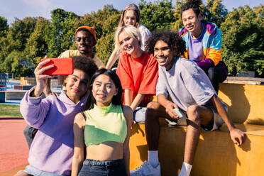 Multikulturelle Gruppe junger Freunde, die sich im Freien treffen und Spaß haben - Stylische, coole Teenager treffen sich im städtischen Skatepark - DMDF02990