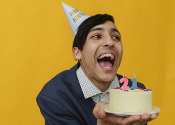 Fröhlicher Mann mit Torte zum 21. Geburtstag im Studio - OSF02038