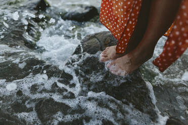 Woman standing on rock in sea - SIF00818