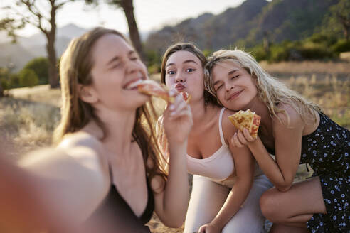 Friends enjoying pizza and taking selfie on weekend - ANNF00363