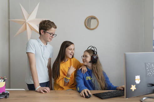 Freunde unterhalten sich am Computer auf dem Tisch zu Hause miteinander - LESF00458