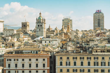 Italy, Liguria, Genoa, Residential rooftops with skyscrapers in background - TAMF03951