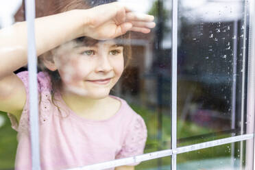 Innocent girl looking through window - WPEF07561