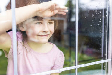 Unschuldiges Mädchen schaut durch das Fenster - WPEF07561