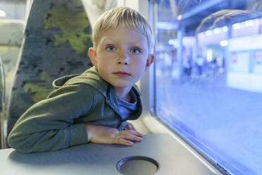 Blonder Junge sitzt im Zug am Fenster - NJAF00548