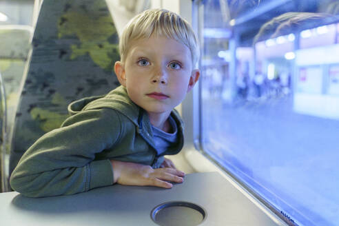 Blonder Junge sitzt im Zug am Fenster - NJAF00548