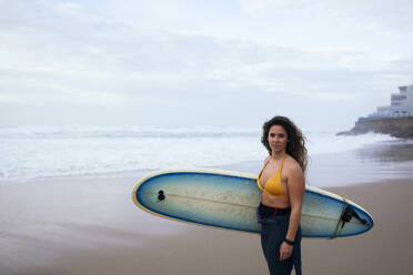 Confident young woman with surfboard at beach on vacation - DCRF01758