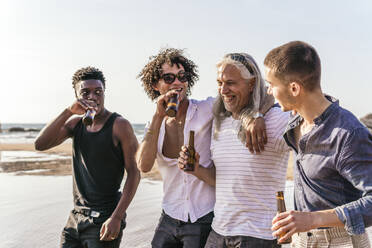 Happy multi-ethnic friends having beer and spending leisure time at beach - PBTF00144