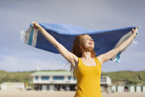 Happy woman with scarf enjoying at beach on holiday - KNSF09725