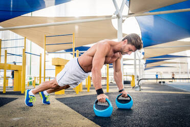 Young athletic man training outdoors - Young adult doing a fitness workout - DMDF03006