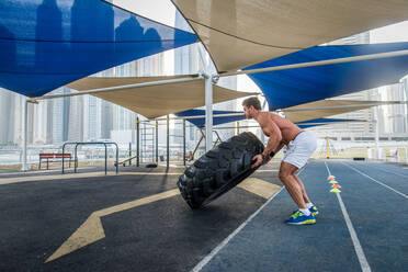 Young athletic man training outdoors - Young adult doing a fitness workout - DMDF03018