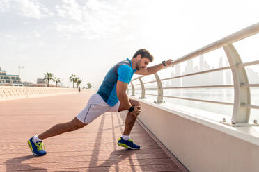 Young athletic man training outdoors - Young adult doing a fitness workout - DMDF03052