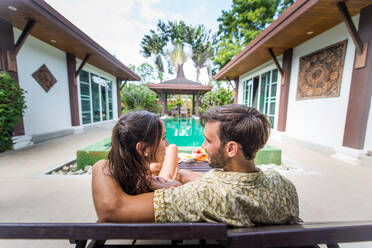 Couple of lovers in a beautiful villa with swimming pool in a tropical climate location - Happy people on a summer vacation, influencers enjoying a luxury resort - DMDF03062