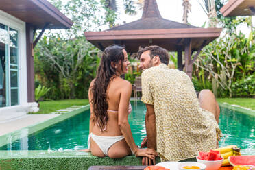 Couple of lovers in a beautiful villa with swimming pool in a tropical climate location - Happy people on a summer vacation, influencers enjoying a luxury resort - DMDF03065