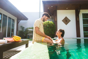 Couple of lovers in a beautiful villa with swimming pool in a tropical climate location - Happy people on a summer vacation, influencers enjoying a luxury resort - DMDF03068