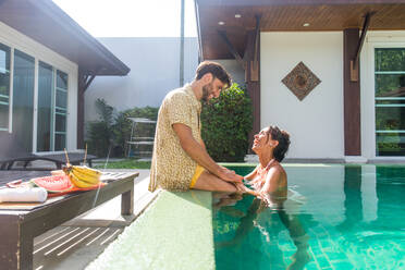 Couple of lovers in a beautiful villa with swimming pool in a tropical climate location - Happy people on a summer vacation, influencers enjoying a luxury resort - DMDF03069