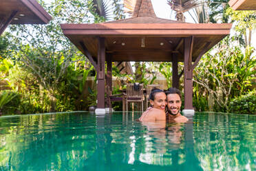 Couple of lovers in a beautiful villa with swimming pool in a tropical climate location - Happy people on a summer vacation, influencers enjoying a luxury resort - DMDF03076