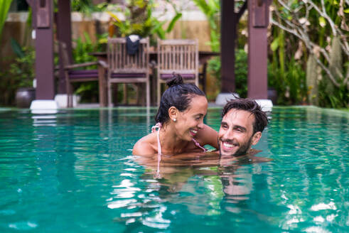 Couple of lovers in a beautiful villa with swimming pool in a tropical climate location - Happy people on a summer vacation, influencers enjoying a luxury resort - DMDF03077