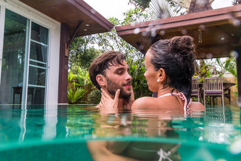 Couple of lovers in a beautiful villa with swimming pool in a tropical climate location - Happy people on a summer vacation, influencers enjoying a luxury resort - DMDF03102