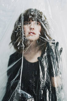 Woman behind transparent plastic in studio - SVCF00386