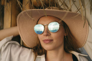 Frau mit Sonnenbrille und Hut im Urlaub - YBF00142