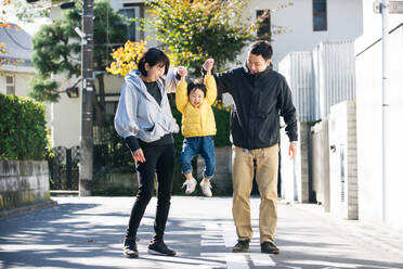 Happy and playful japanese family with small cute daughter having fun outdoors - DMDF03121