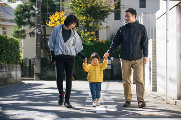 Happy and playful japanese family with small cute daughter having fun outdoors - DMDF03122