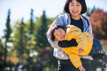 Happy and playful japanese family in a park in Tokyo - DMDF03123