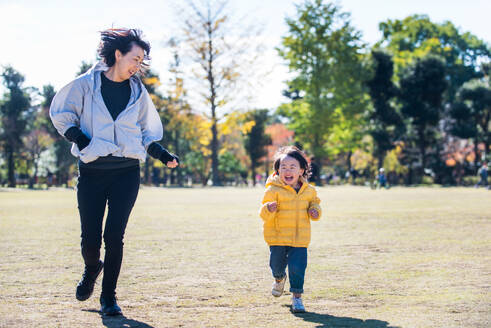 Happy and playful japanese family in a park in Tokyo - DMDF03125