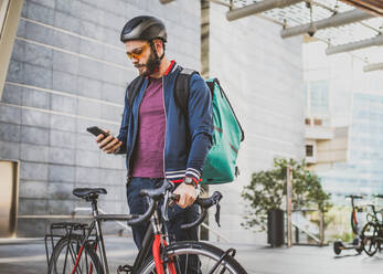 Lebensmittellieferdienst, Fahrer, der mit dem Fahrrad Essen in Kliniken ausliefert - Konzepte zu Transport, Lebensmittellieferung und Technologie - DMDF03178