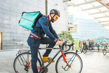 Lebensmittellieferdienst, Fahrer, der mit dem Fahrrad Essen in Kliniken ausliefert - Konzepte zu Transport, Lebensmittellieferung und Technologie - DMDF03180