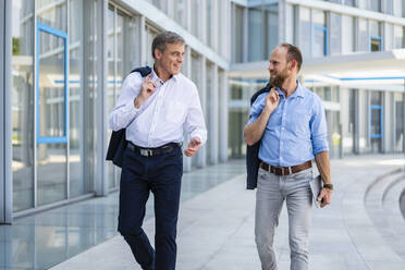 Two managers walking in modern building talking business - DIGF20451