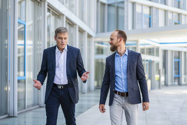 Two managers walking in modern building talking business - DIGF20453
