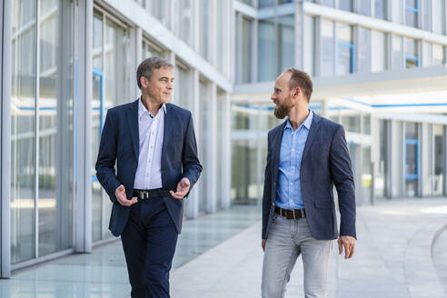 Two managers walking in modern building talking business - DIGF20454