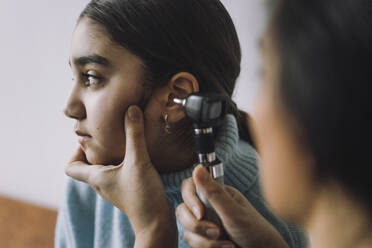 Doctor doing hearing test of female patient through Otoscope at hospital - MASF37573