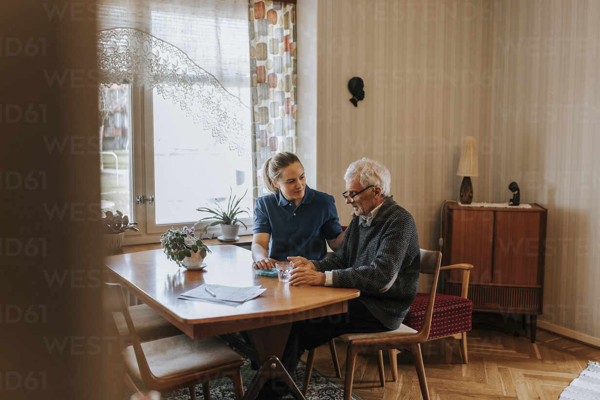 Weibliche Pflegehelferin Im Gespräch Mit Einem älteren Mann Bei Der Einnahme Von Medikamenten Zu 