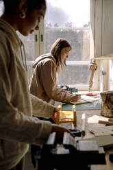 Side view of female teenage students learning during carpentry class - MASF37701