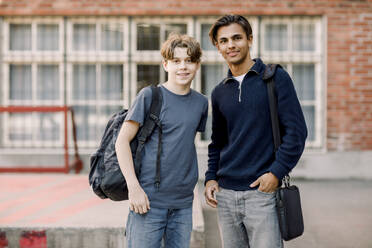 Portrait of smiling teenage male students standing together in high school campus - MASF37789