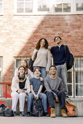 Fröhliche Schülerinnen und Schüler vor einem Schulgebäude - MASF37794
