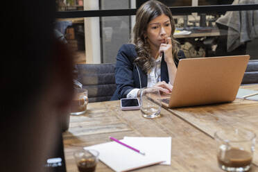 Worried businesswoman looking at laptop in board room - MASF37817