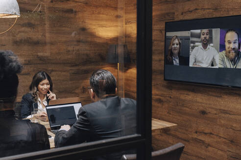 Business colleagues discussing through video conference in board room during meeting - MASF37825