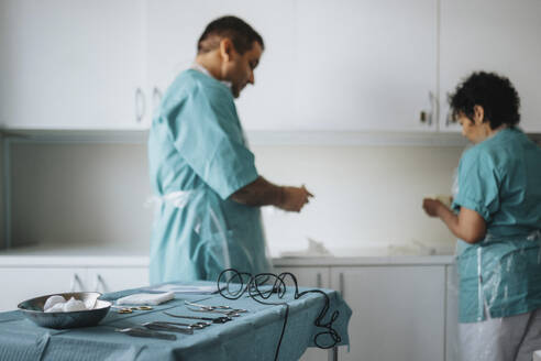 Male and female surgeons getting ready for surgery in hospital - MASF37900