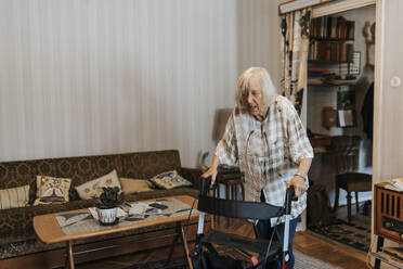 Senior woman using mobility walker while walking at home - MASF37952