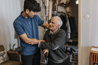 Senior man thanking male healthcare worker at home - MASF37977