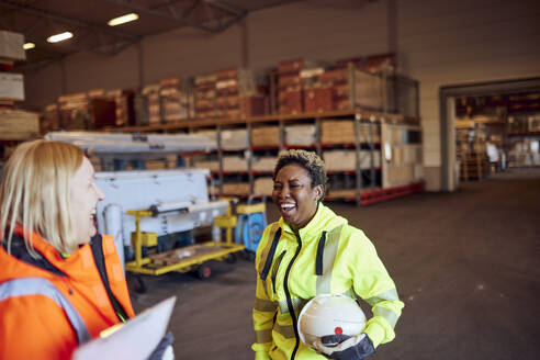 Cheerful multiracial female blue-collar workers in distribution warehouse - MASF38199